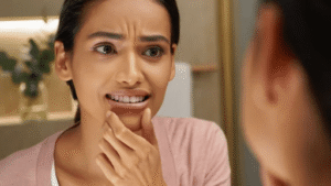 Imagen realista de una persona observando sus dientes frente al espejo con expresión reflexiva, ideal para ilustrar las verdades del blanqueamiento dental.