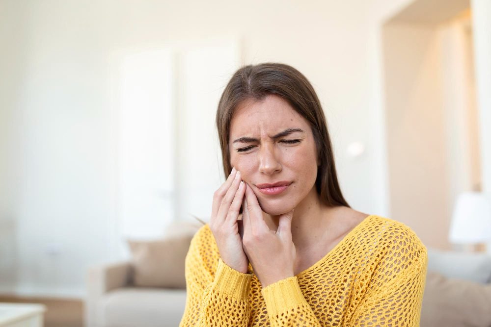 Una mujer que está sintiendo un molesto dolor de muelas