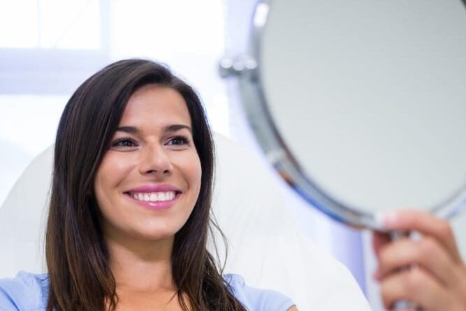 Una paciente sonriendo saliendo de una consulta odontológica