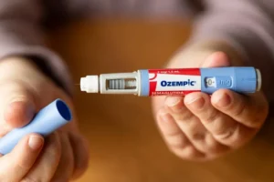 Pluma de Ozempic (semaglutida) sostenida en las manos de un paciente
